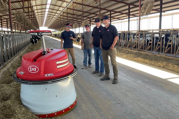 San Joaquin Valley Dairy Robotics team inspecting the Lely Juno automatic feed pusher