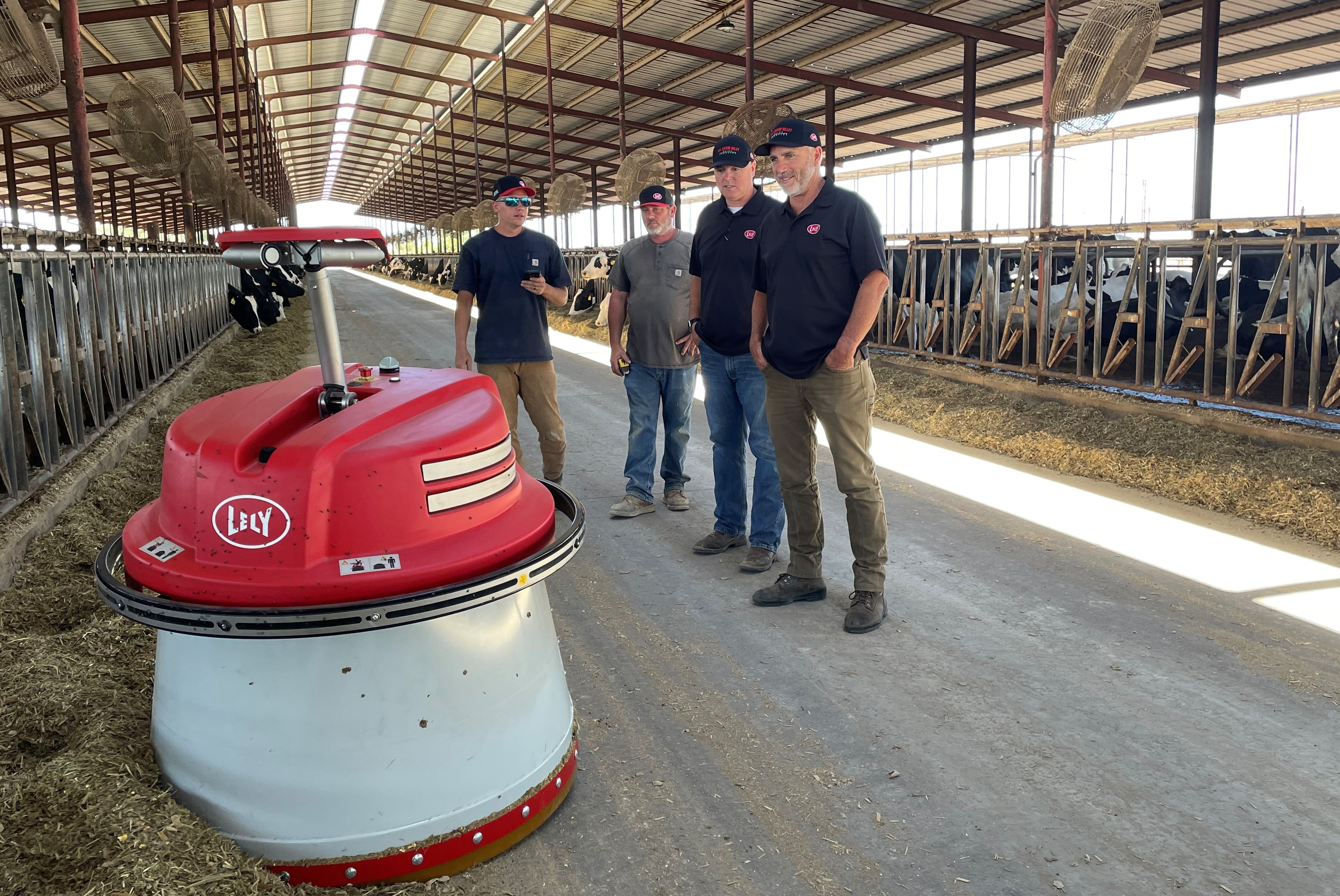 San Joaquin Valley Dairy Robotics team inspecting the Lely Juno automatic feed pusher